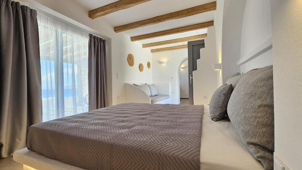 a bedroom with a bed and a large window at Polychronis Private Suite in Pollonia