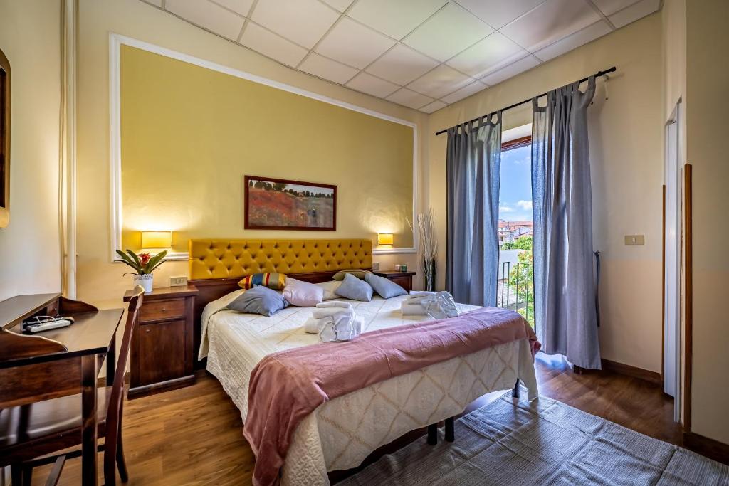 a bedroom with a bed and a desk and a window at Hotel Minerva in Pisa