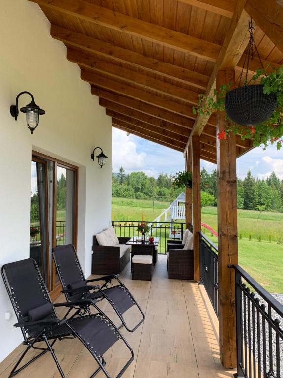 a patio with chairs and a wooden pergola at ORAWSKA CHATA pod Babią Górą in Zubrzyca Górna