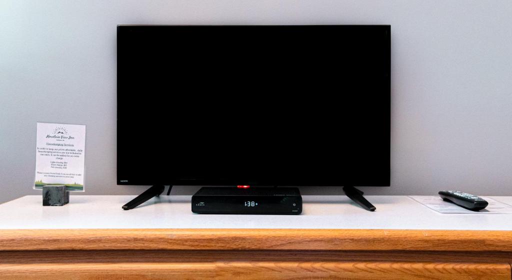 a flat screen tv sitting on top of a dresser at Mountain View Inn in Canmore