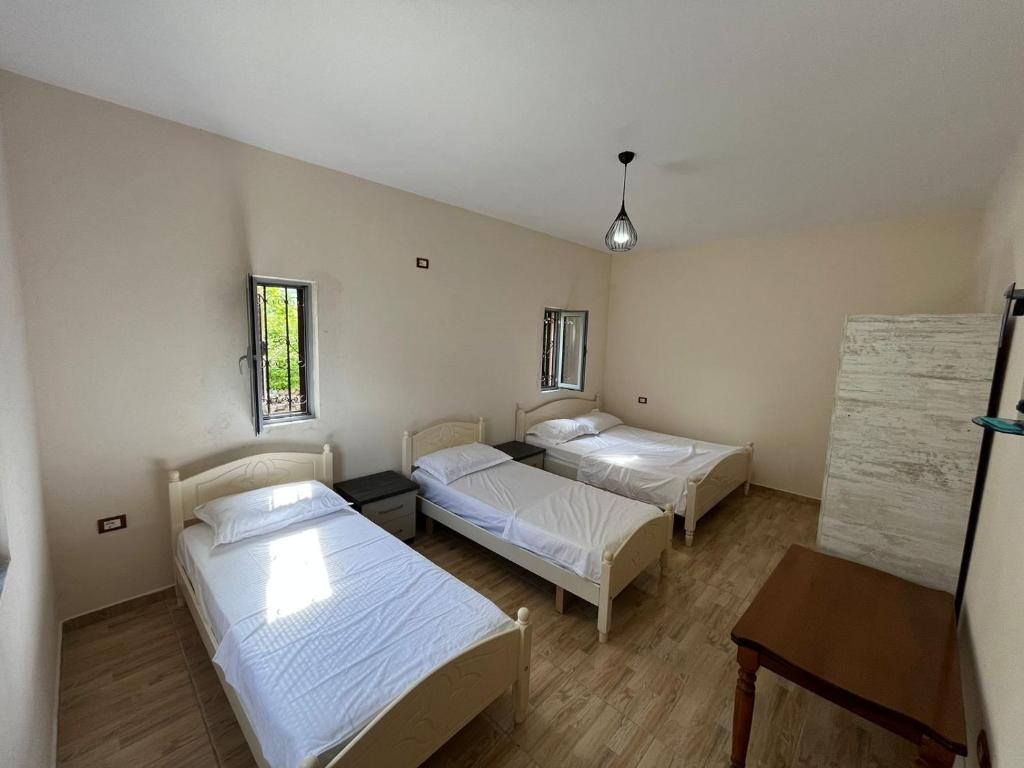 a room with two beds and a table at Arditi's Villa in Shkodër