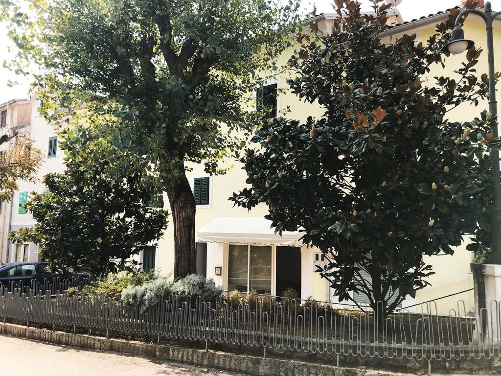 a white house with a fence in front of it at Placa Apartments in Mošćenička Draga