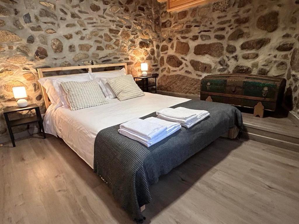 1 dormitorio con 1 cama con toallas en Casa dos Senadores by Vale do Zêzere Hotel en Manteigas