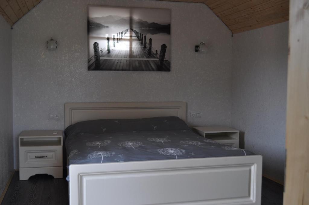 a bedroom with a bed with a painting on the wall at Кукул in Vorokhta