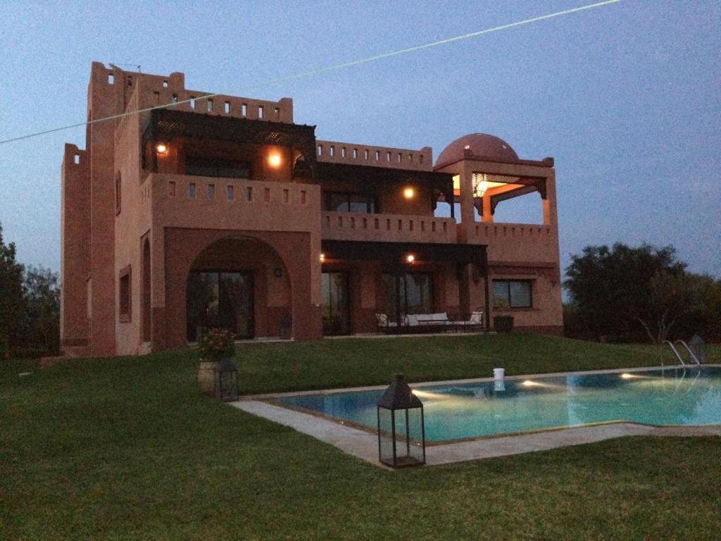 a large house with a swimming pool in front of it at Villa Marrakech in Marrakesh