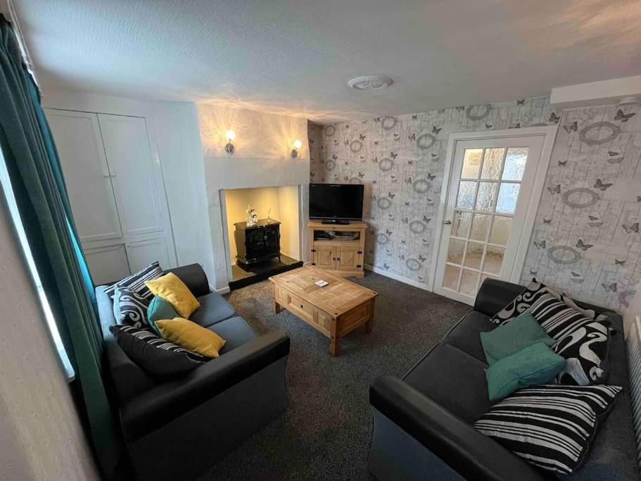 a living room with a couch and a tv at Fisherman Cottage Morecambe in Morecambe
