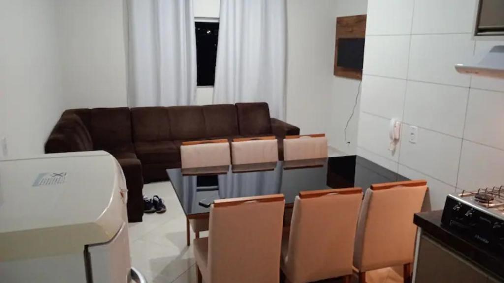 a living room with a couch and a table and chairs at ap das hortências in Poços de Caldas