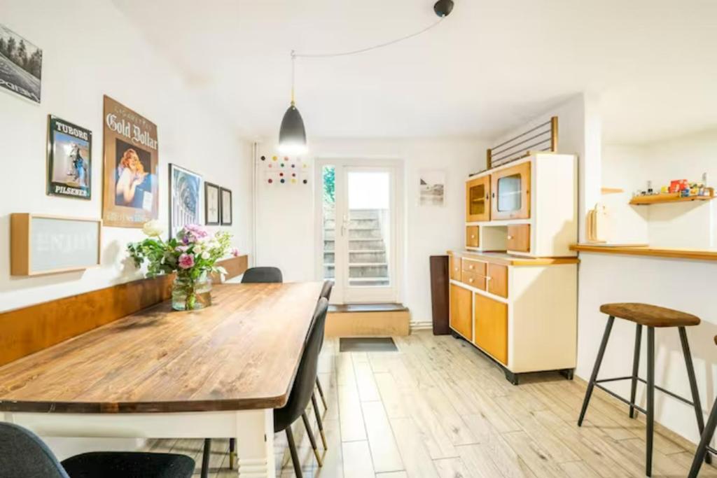 een keuken en eetkamer met een houten tafel en stoelen bij Gemütliche 3-ZKB WC SouterrainWohnung in Bestlage in Hamburg