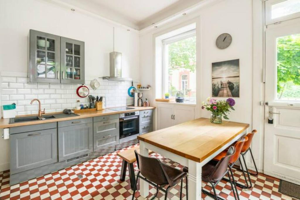 una cocina con mesa de madera y sillas. en Großzügige Altbauwohnung in Bestlage en Hamburgo