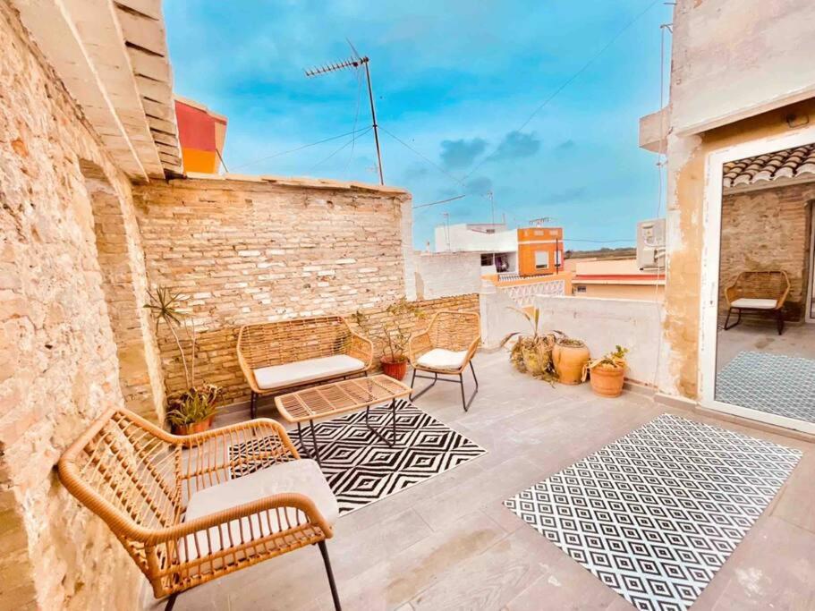 eine Terrasse mit Stühlen und Tischen auf einem Gebäude in der Unterkunft casa Albufera boutique in Valencia