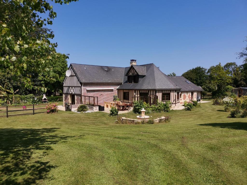 a large house in a yard with a grass field at Le manège Gite Le phare in Sainte-Marie-au-Bosc