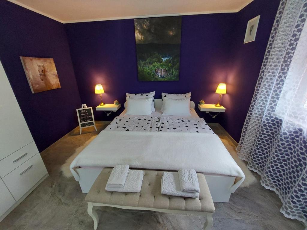 - une chambre avec un grand lit et des murs violets dans l'établissement Studio apartman Marta, à Korenica