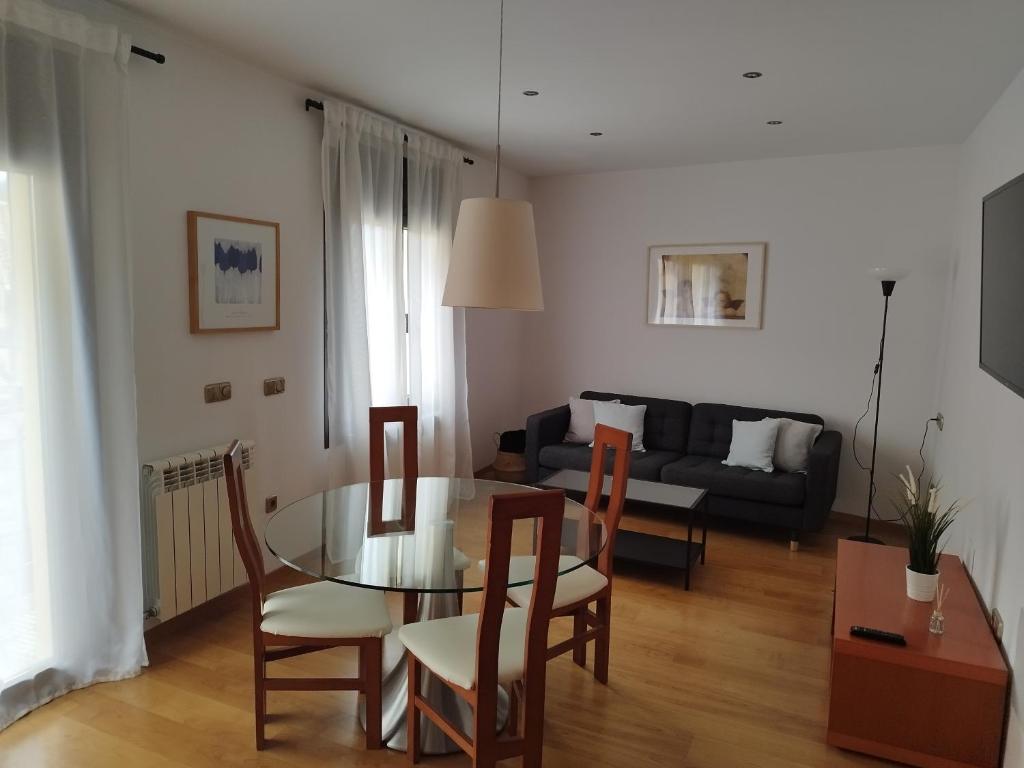 a living room with a table and chairs and a couch at CAL JAN - CADÍ in Bellver de Cerdanya 