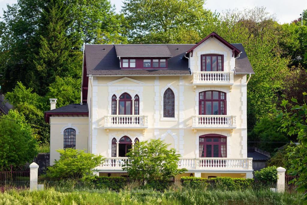 uma grande casa branca com um telhado preto em Villa l'Orante em Lourdes