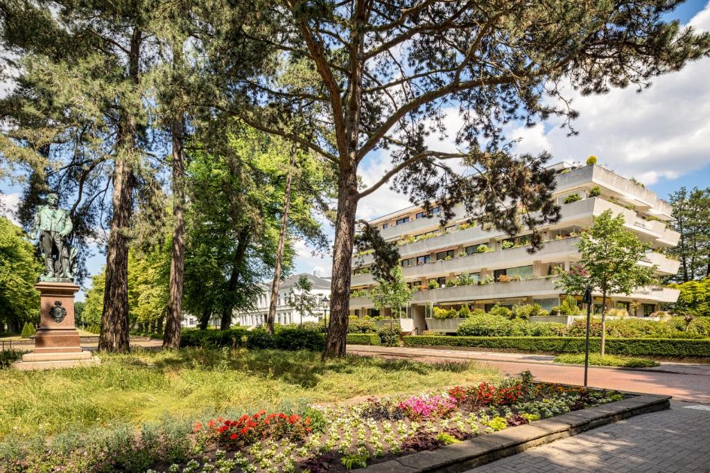 a building in a park with flowers and trees at Stilvolle Stadtoase, 116 qm, Parkblick, Wassernah, Parkplatz in Wilhelmshaven