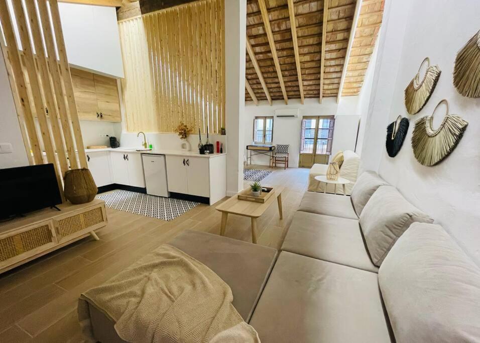 a living room with a white couch and a kitchen at Loft Albufera in Valencia