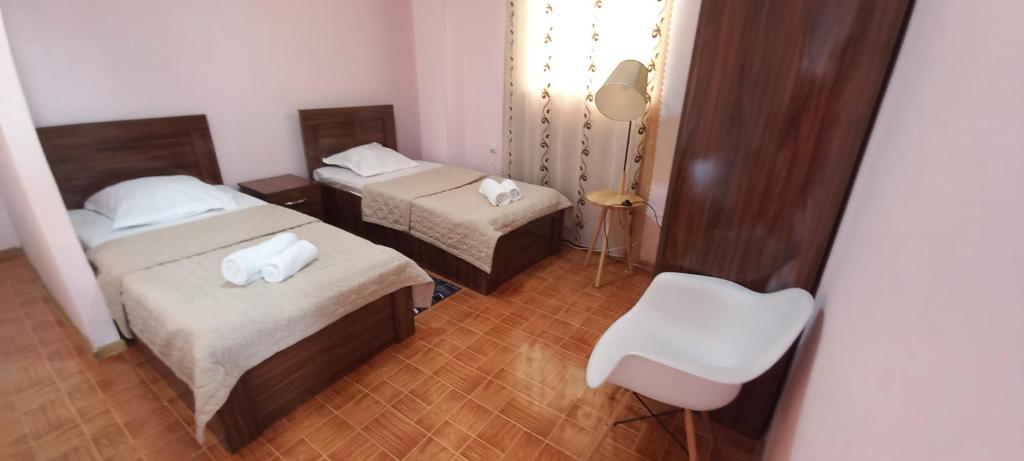 a small room with two beds and a chair at Guest House LIBU Zugdidi in Zugdidi