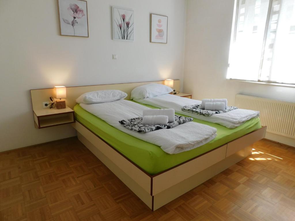 - une chambre dotée d'un lit avec des draps verts et blancs dans l'établissement Apartment Riverside, à Ljubljana