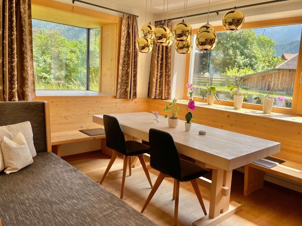 ein Esszimmer mit einem Tisch, Stühlen und einem Fenster in der Unterkunft Bio Apartment - Der Steinadler in Umhausen