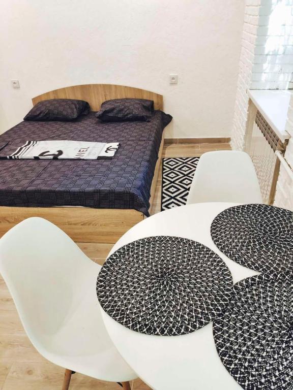 Habitación con 1 cama, 2 mesas y sillas en Студия с Джакузи на Молодогвардейской, en Mykolaiv