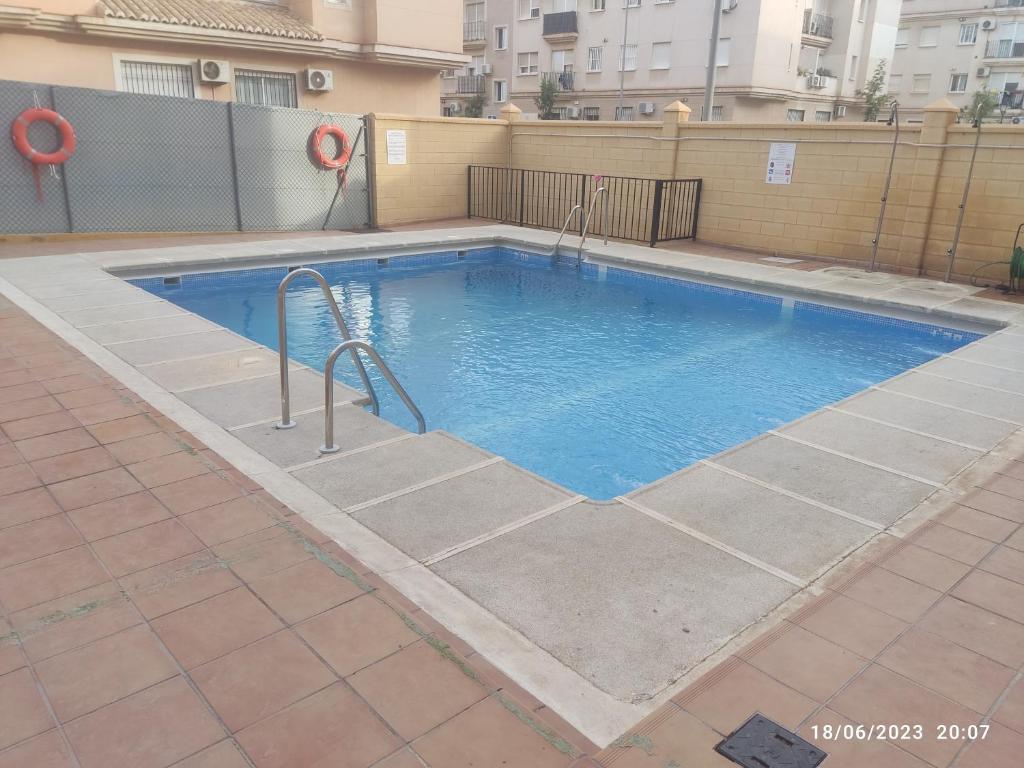 una grande piscina con acqua blu in un edificio di Apartamento VILLA INÉS parking y wifi gratis a Huércal de Almería