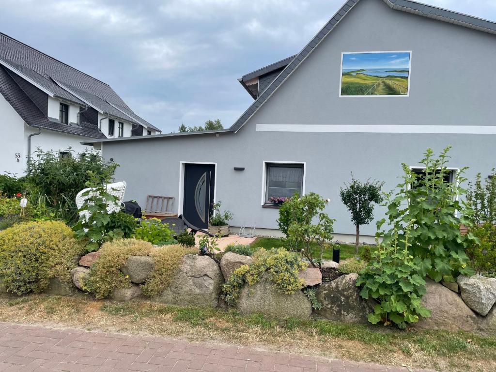 une maison blanche avec une clôture en pierre devant elle dans l'établissement Ferienwohnung Fiene, à Groß Zicker