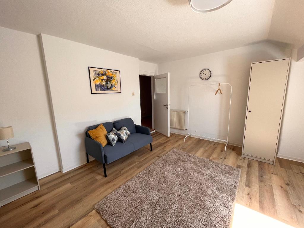 Ein schönes Zimmer in Kiel في كيل: غرفة معيشة مع أريكة زرقاء وسجادة