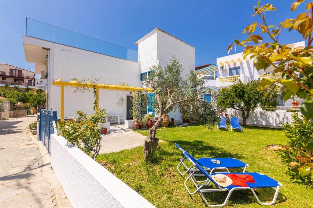 a blue bench in the yard of a house at Joanna Apartments in Agia Pelagia