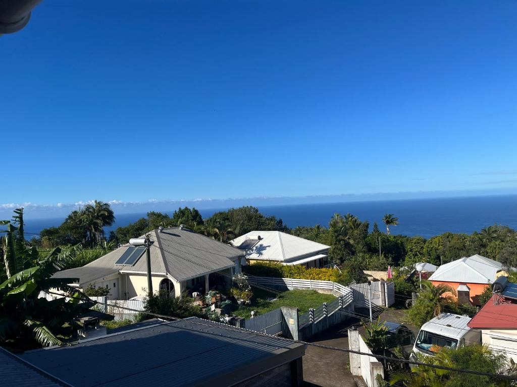 an aerial view of a house with the ocean in the background at Maison de vacances du sud in Saint-Joseph