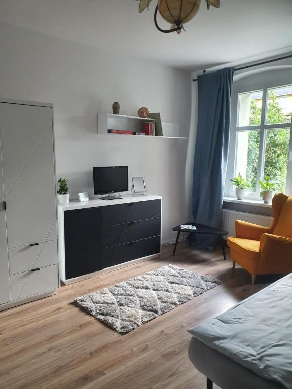 een woonkamer met een tv en een dressoir bij Kamienica Nowodworska 30 in Bydgoszcz