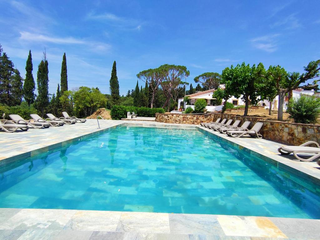 een zwembad met stoelen en een villa bij Casa Cuatro Vientos in Tordera