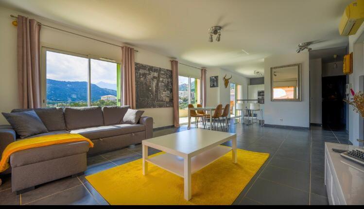 uma sala de estar com um sofá e uma mesa em Chez Pasqua ! Appartement spacieux avec terrasse 2 chambres 6 couchages en Rooftop em LʼÎle-Rousse