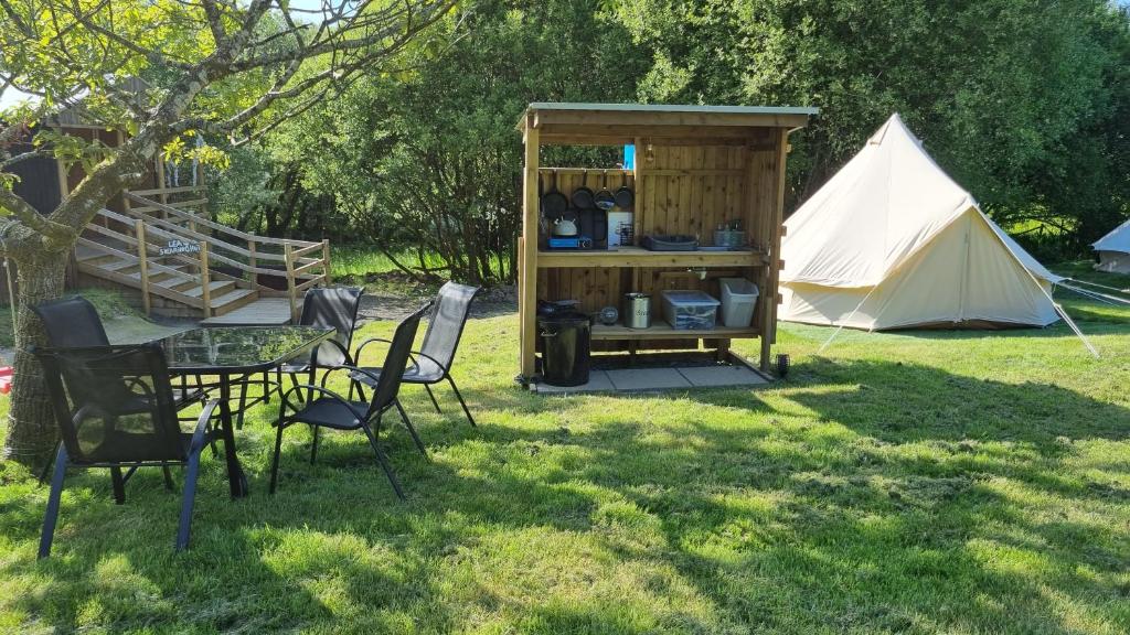 a tent and a table and chairs in the grass at Route 47 Glamping Bell Tents in Cross Hands