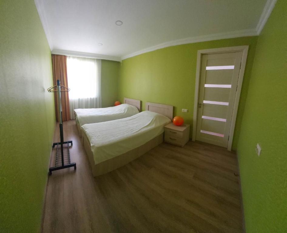 a green room with a bed and a ladder at M7 House in Gorists'ikhe