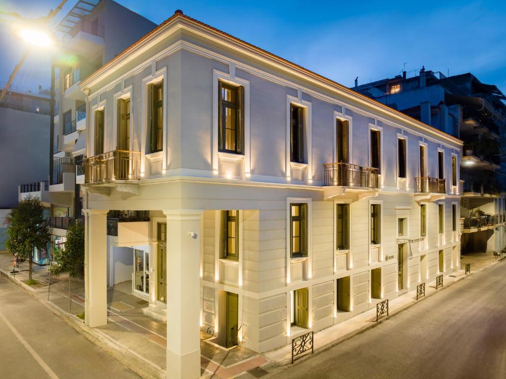 a white building on a street at night at Eramai in Patra