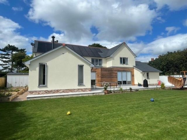 a white house with a lawn in front of it at Luxury Devon House in Chulmleigh