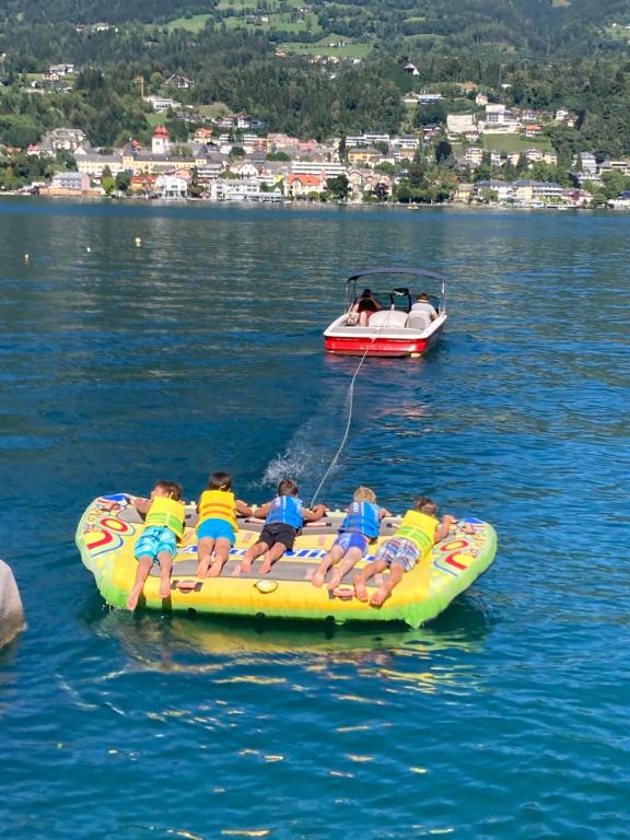 a group of children riding on a raft in the water at Familienchalets am Millstätter See in Rothenthurn