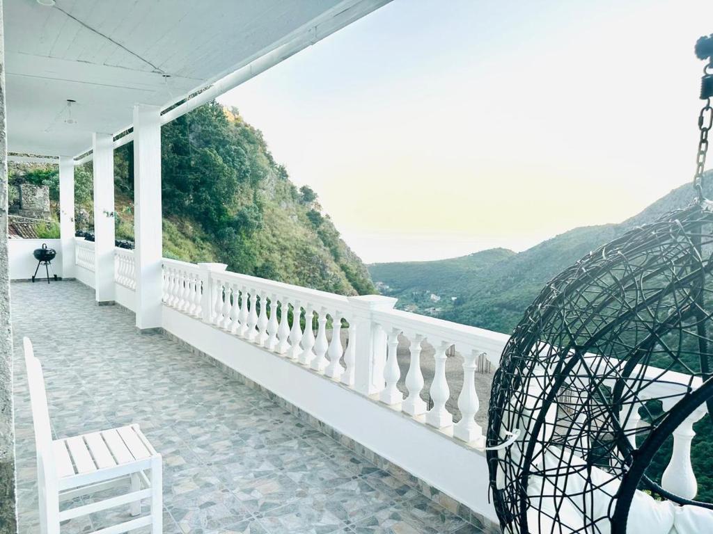 a white porch with a chair and a view of the mountains at SWEET HOME in Himare