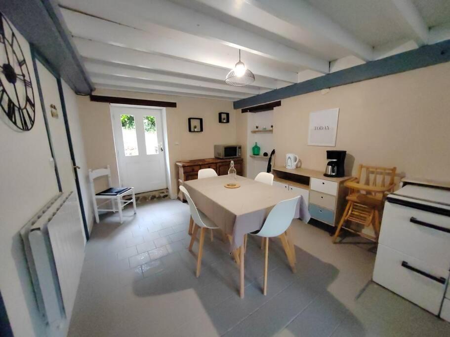 Una cocina y un comedor con mesa y sillas. en Gîte du Connétable, en Couville