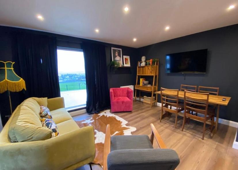 uma sala de estar com um sofá e uma sala de jantar em Studio 11 em Portstewart