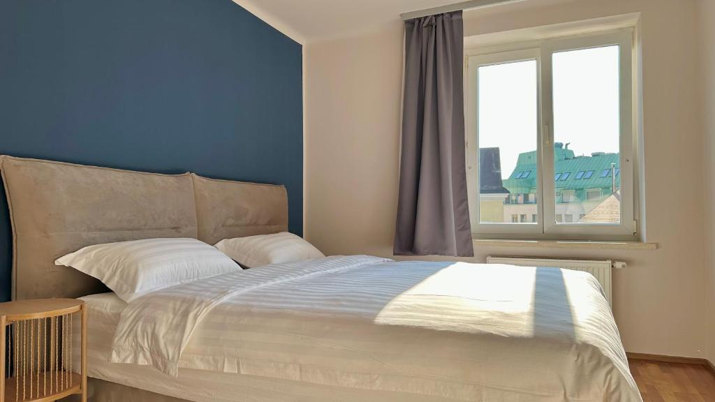 a bedroom with a large bed with a window at Homely Stay Apartment 2 in Sankt Pölten