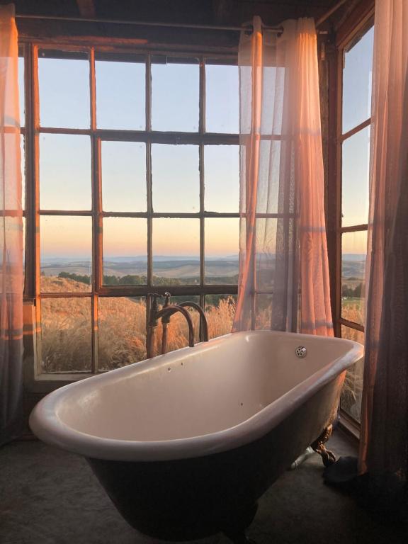 a bath tub in a room with a large window at Infinity at Enfin Estate in Nottingham Road