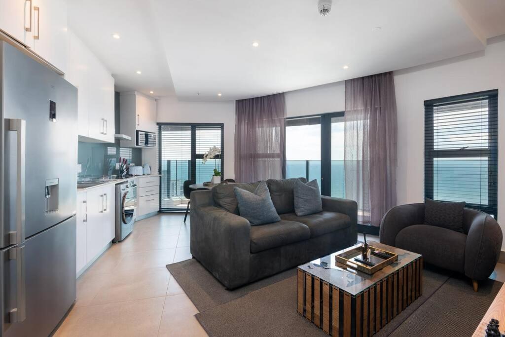 a living room with a couch and a table at Lux Oceans 2 Bedroom Apartment in Umhlanga in Durban