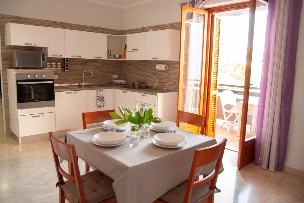 Una cocina y un comedor con mesa y sillas. en Casa Romualdo, en Monopoli