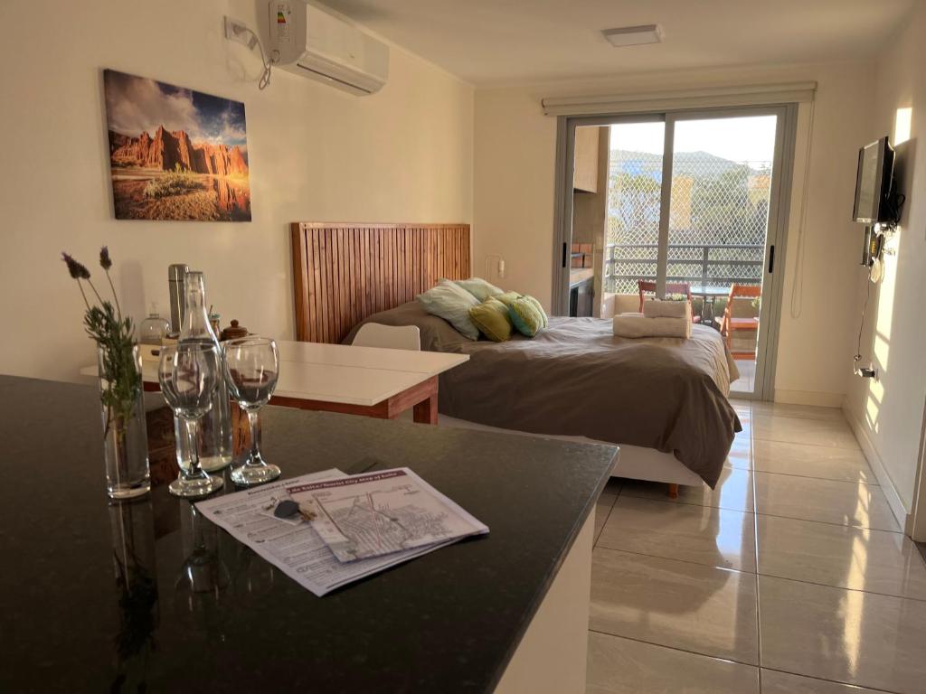 Sala de estar con cama y mesa con sidra de mesa en Andes Suites Premium en Salta