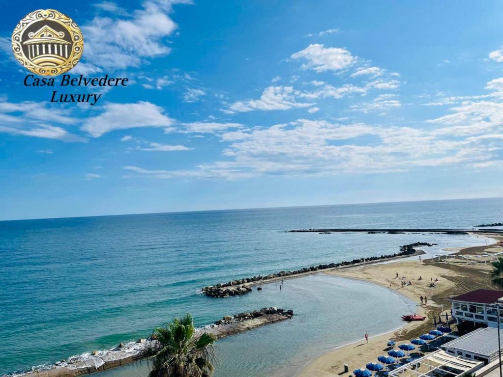 uma vista para uma praia com guarda-sóis e para o oceano em Casa belvedere luxury em Anzio