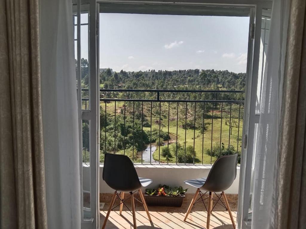 two chairs sitting on a balcony looking out of a window at Sky Nest Grey point 306 in Kericho