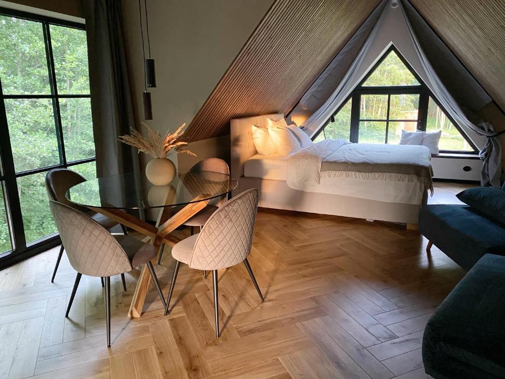 a bedroom with a bed and a glass table and chairs at Heinaläku puhkemaja loft in Paope