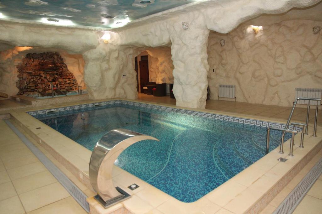 a large swimming pool in a building with a large swimming pool at Kleopatra VIP hotel in Kamianets-Podilskyi