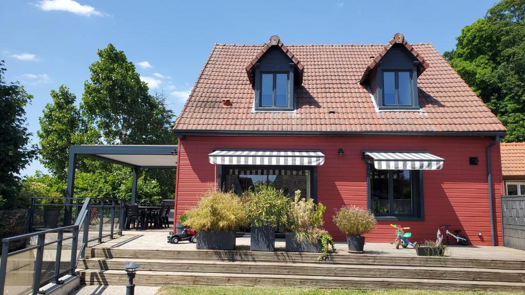 una casa roja con plantas delante de ella en La Gitane, en Saint-Valery-sur-Somme